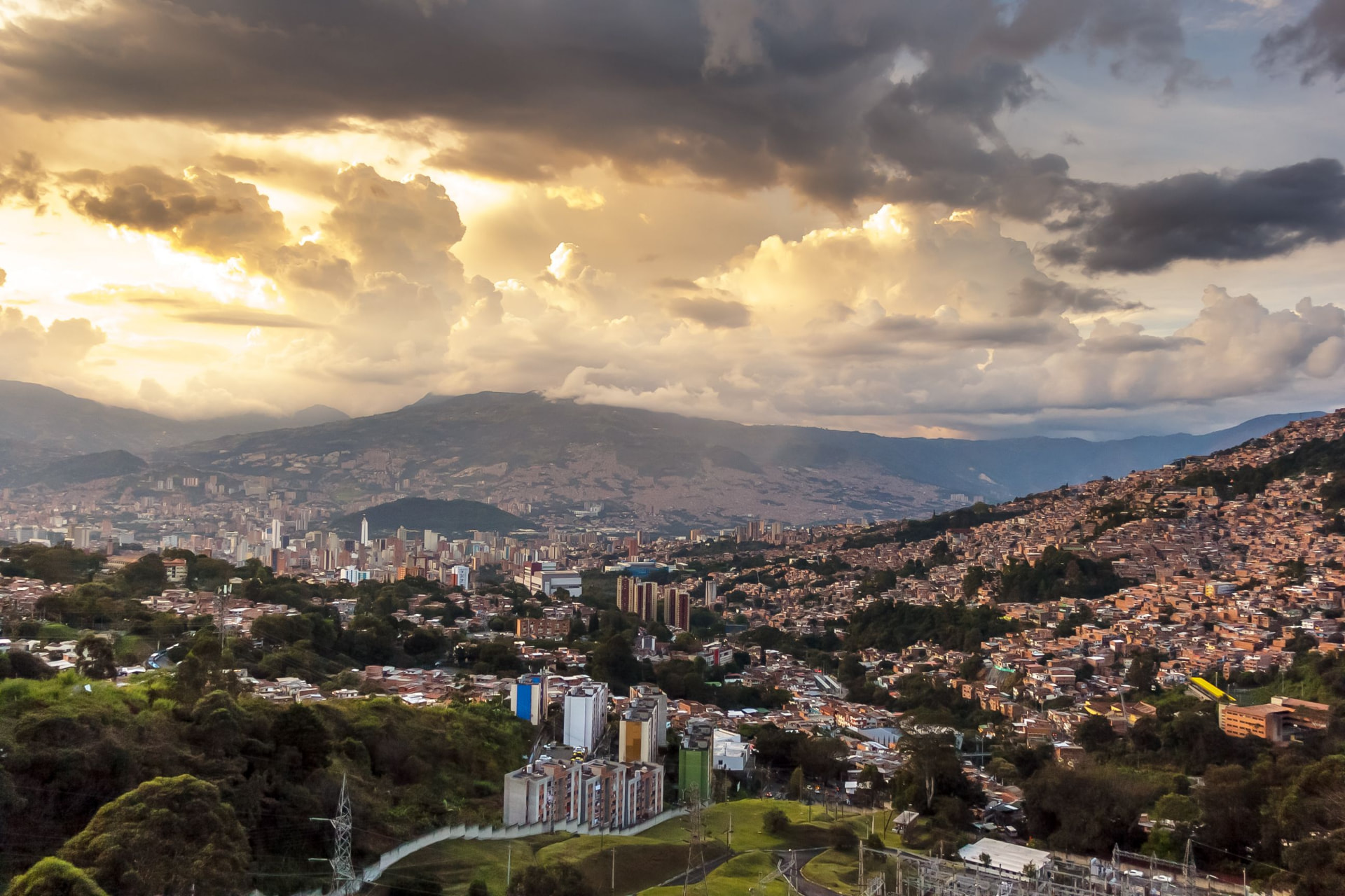 Panoramic view of Medellín, Colombia spread across its green mountain valley at golden hour